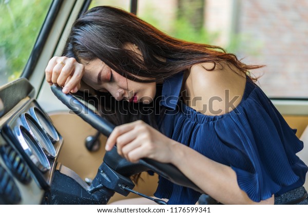 young woman sleeps in\
the vintage car 