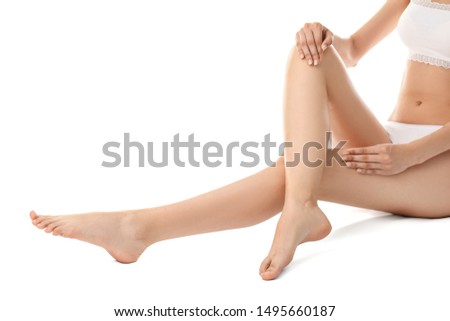Young woman with slim legs on white background