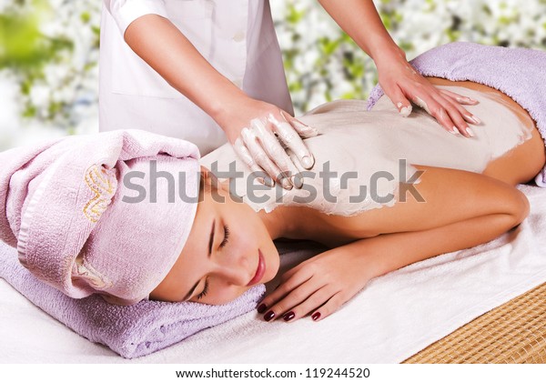 Young woman with slimming body thermal mask on
her back. Spa Treatment.