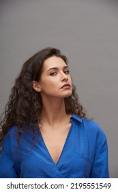 Young Woman In Smart Casual Dress With V Neck Posing In Front Of Camera During Photo Session While Standing Against Grey Background