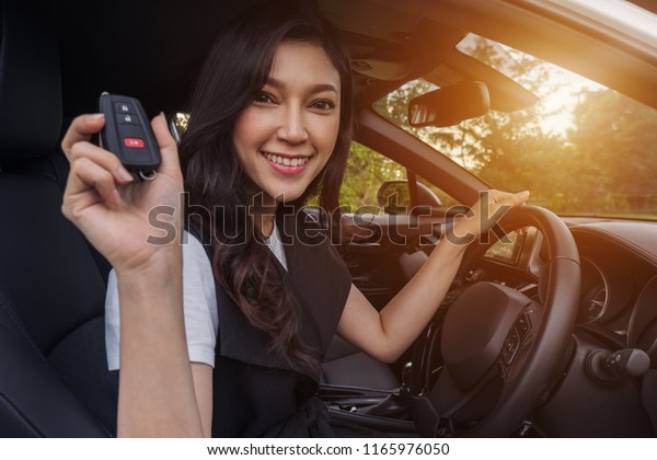 young woman with\
smart key remote in a car