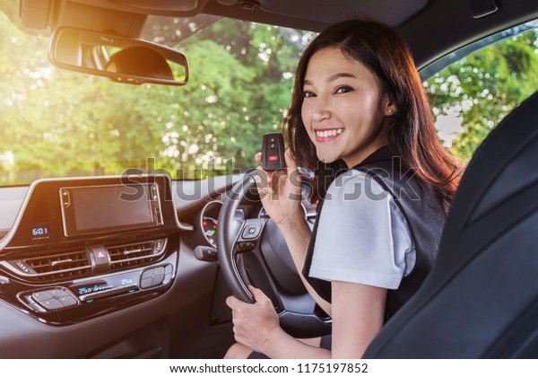 young woman with
smart key remote in a car