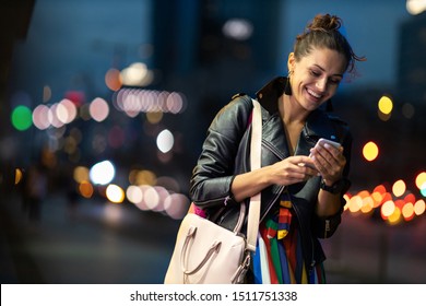 Young Woman With Smartphone At Night In A Urban City Area