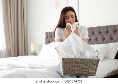 Young Woman Smelling Fresh Laundry In Bedroom. Space For Text