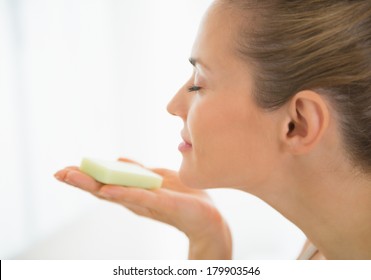 Young Woman Smelling Soap Bar