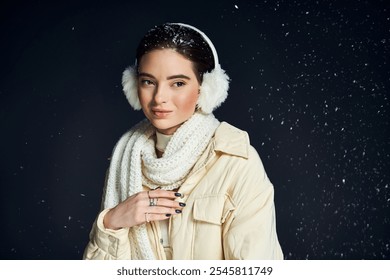 A young woman smiles softly while surrounded by falling snowflakes, dressed in cozy winter attire. - Powered by Shutterstock