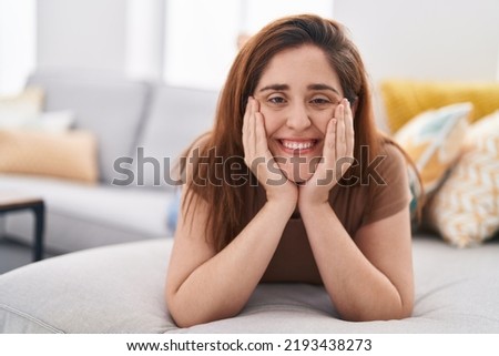 Young woman smiling confident lying on sofa at home