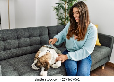 Young Woman Smiling Confident Using Pet Hair Remover Brush At Home