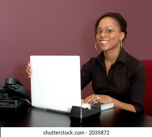 Young Woman Smiling With Laptop Computer In Office Setting