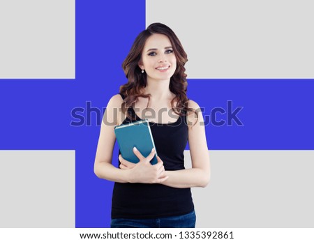 Young woman smiling and posing against the Finnish flag background. Finnish language school and travel concept