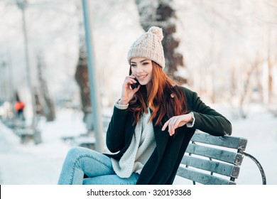 Young  Woman Smiling With Smart Phone And Winter Landscape 