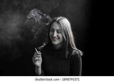 Young Woman Smoking Cigarette On Black Background