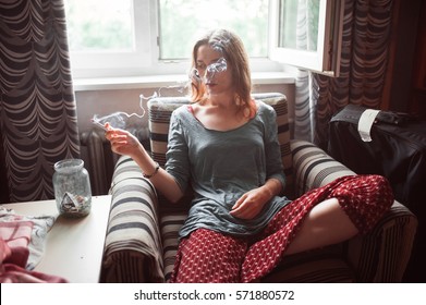 Young Woman Smoking Indoors At A Window (portrait With Copy Space)