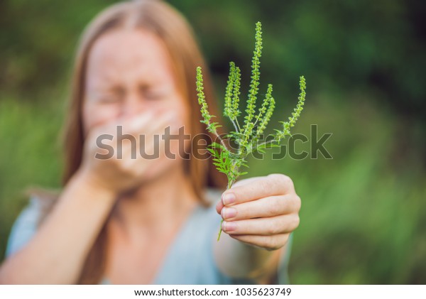 Young\
woman sneezes because of an allergy to\
ragweed