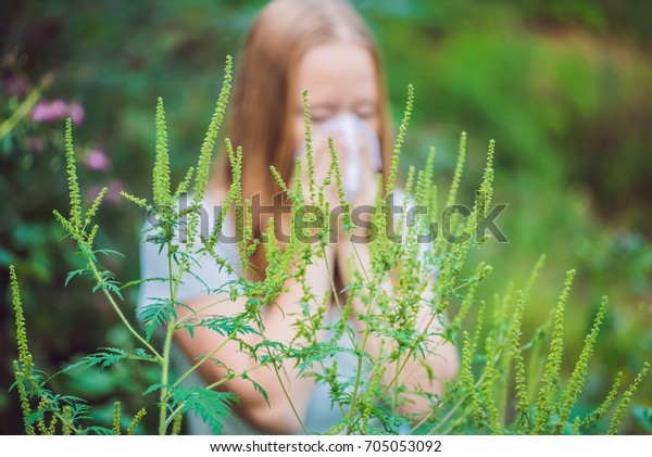 Young\
woman sneezes because of an allergy to\
ragweed.