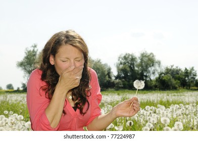 young woman sneezes on a flower meadow