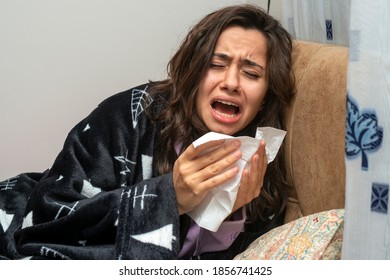 Young Woman Sneezing Suffering From Virus Infection. Home Quarantine Due To Covid Disease.