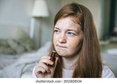 Young Woman Is Sniffing Essential Oil. Loss Of Smell And Taste From Covid