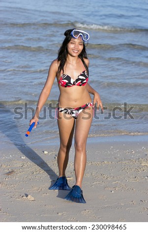 Young woman with snorkeling gear on beach