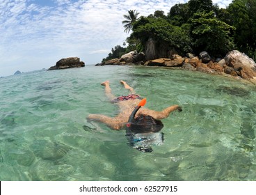 young woman snorkeling at a tropical beach at perhentian islands,malaysia