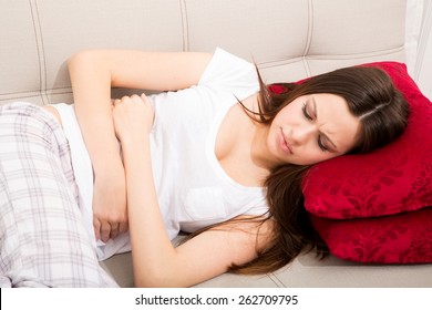 Young Woman In The Sofa With Period Pain
