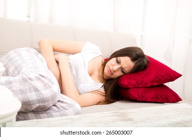 Young Woman In The Sofa With Period Pain
