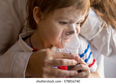 Young woman with son doing inhalation with a nebulizer at home. Mother of a young child making inhalation - Shutterstock ID 578816740