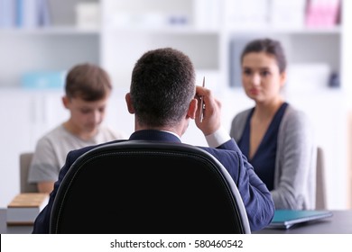 Young woman with son during teacher-parent meeting at school