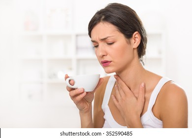 Young Woman With A Sore Throat Drinking Tea