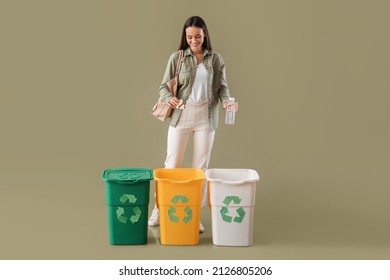 Young woman sorting plastic bottle and paper on color background