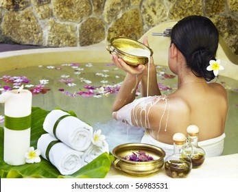 Young Woman At Spa Centre Taking Milk Bath