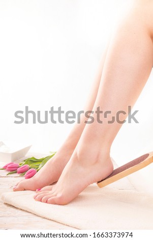 Young woman at SPA pedicure, using a foot file. Beauty legs, feet, heel.