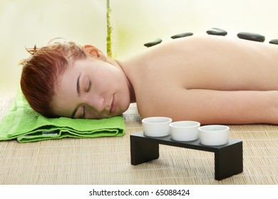 Young Woman In Spa With Rocks On Her Back