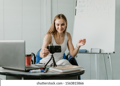 Young woman speaking in front of camera for vlog as blogger. Caucasian businesswoman working, recording video tutorial at office. Earn extra money, Side hustle, money making, turning hobbies into cash - Powered by Shutterstock