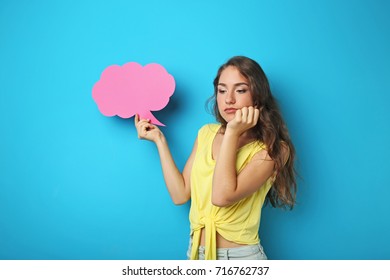 Young woman with speech bubble on blue background - Shutterstock ID 716762737