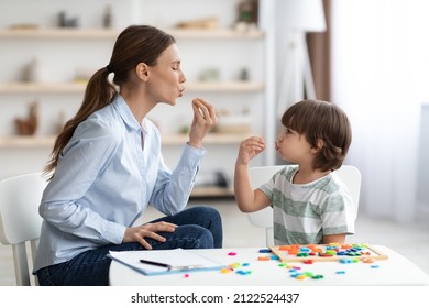 Young woman speech therapist studying together with small kid, learning practice pronunciation exercises with little boy child at office, free space - Shutterstock ID 2122524437