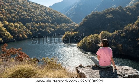 Young woman spend free time among nature, relaxing enjoying amazing scenic view of mountain in Rhodopes mountains, Bulgaria. Weekend nature getaway, travel, vacation outdoor, hiking. Panoramic