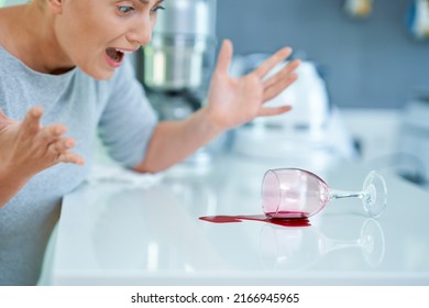 Young Woman And Spilled Wine In The Kitchen