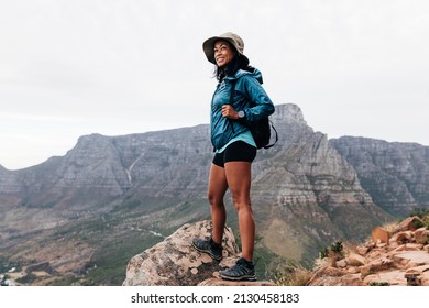 Young Woman In Sports Clothes And Hat Enjoying The View During A Hike