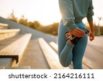 Young woman in sports outfit doing exercises outdoors in the morning. Sport woman doing stretching exercise. Sport, Active life, sports training, healthy lifestyle.