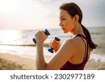 Young woman in sports outfit doing exercises in the morning in the beath. Sport, Active life, sports training, healthy lifestyle.