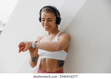 Young woman in sportswear looking at smartwatch and counting calories burned. Healthy life concept