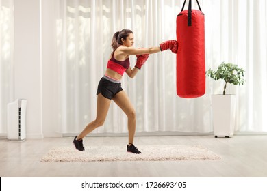 Young Woman In Sportswear Practicing Boxing At Home