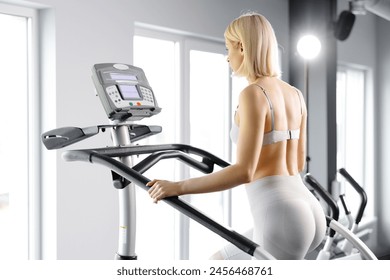 Young woman in sportswear working out at the gym. She is working out on stairway simulator. - Powered by Shutterstock