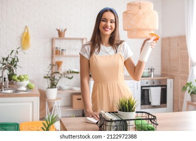 Young Woman With Spray Bottle In Kitchen