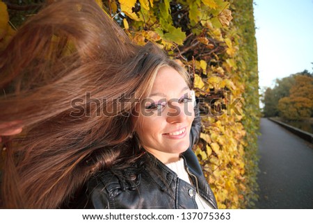 Young woman stand autumn leaves fall yellow green girl garden background long hair