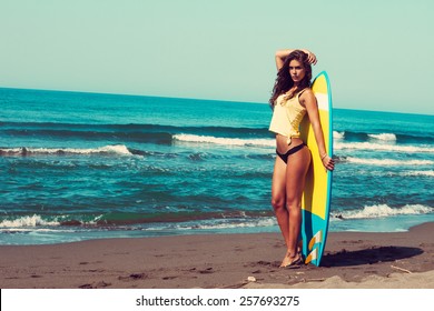 young woman stand on beach hold surfboard , sunny summer day, full body shot