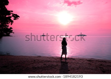 Young woman standing of beautiful sunset on the beach, for vacat