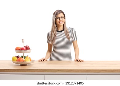 Young Woman Standing Behind A Wooden Worktop With A Fruit Plate Isolated  On White Background