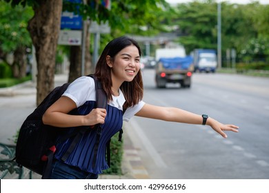 Young woman standing at bus stop on street of city. Asian student girl waiting  bus in private dress at Public transport  in Thailand - Powered by Shutterstock